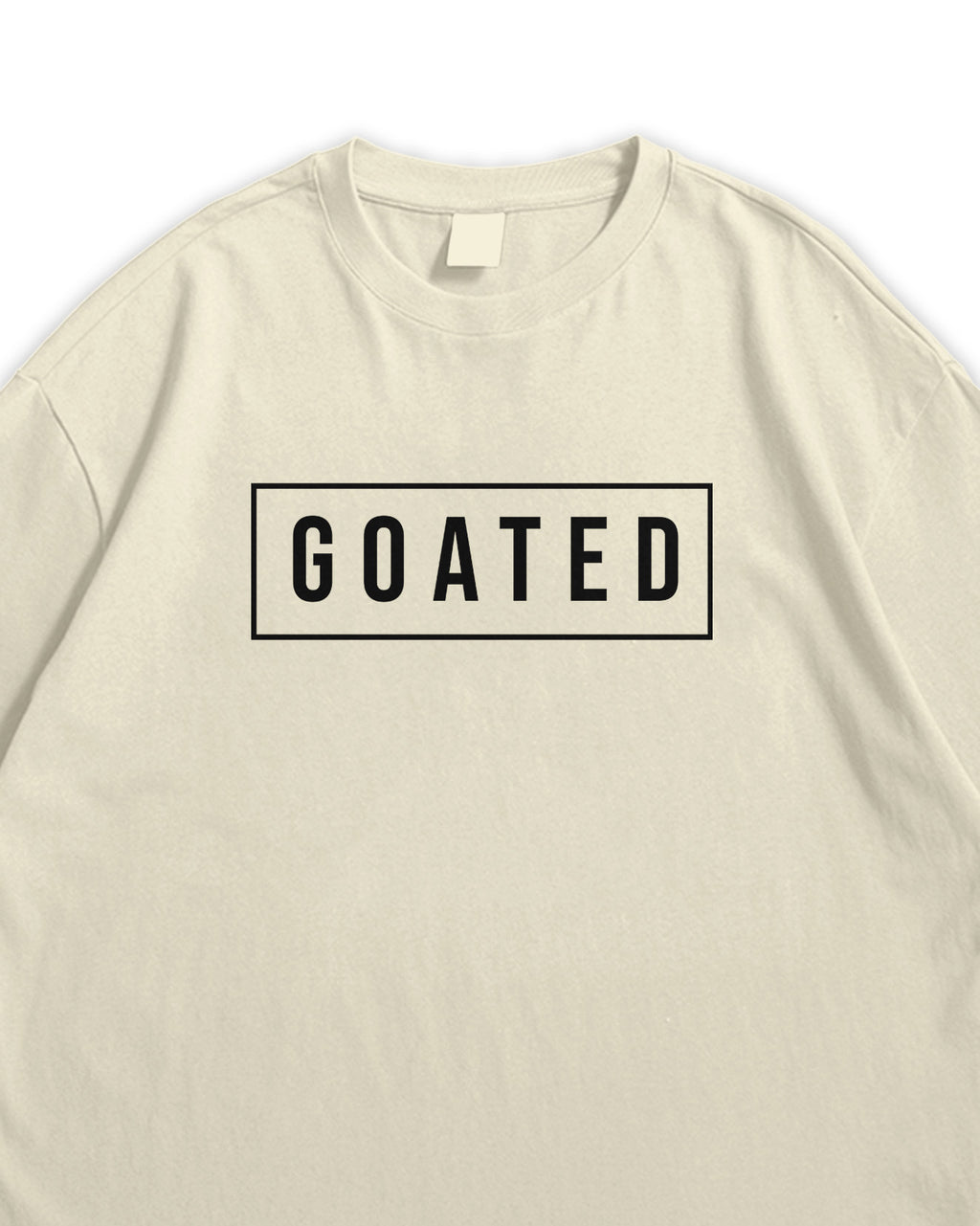 Beige t-shirt with 'GOATED' text on a white background